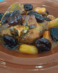 Une assiette comprenant une portion de poulet garnie d'olives
